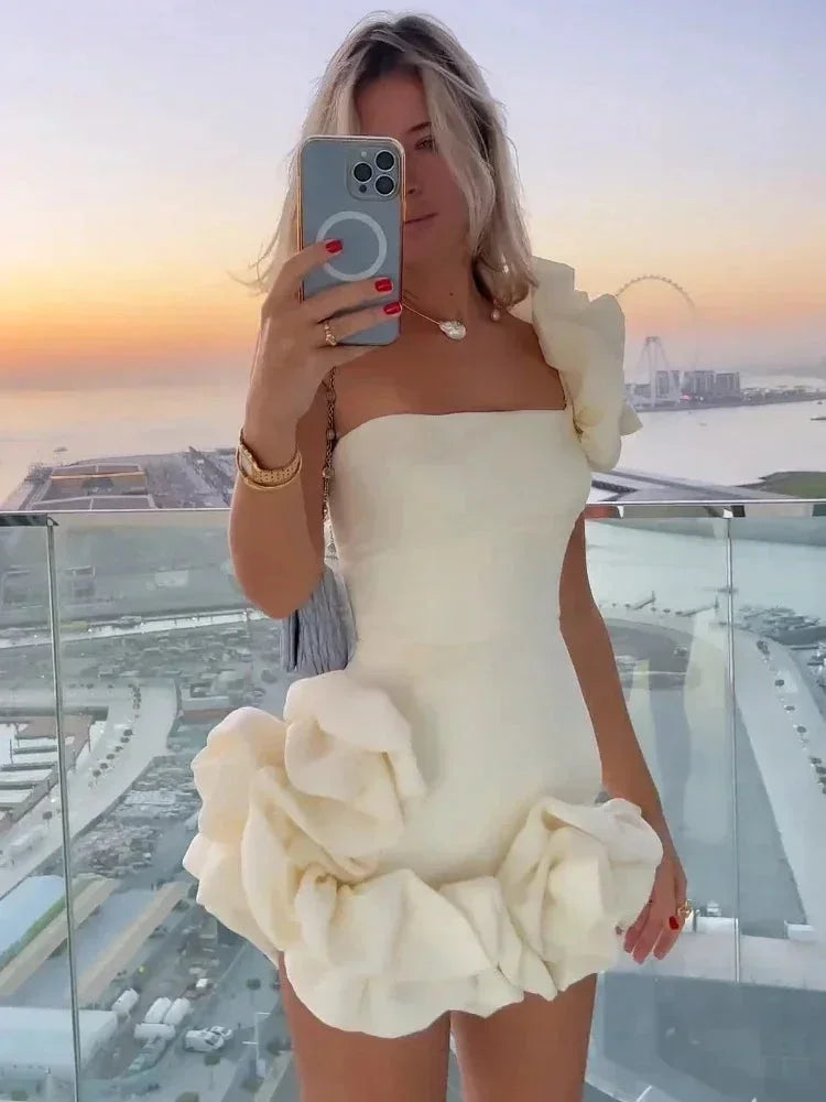 Robe courte bustier à volants asymétriques en tissu léger, parfaite pour les soirées, avec détails fluides et séduisants.