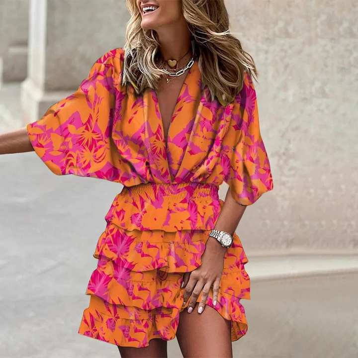 Robe courte cache-cœur à manches évasées en tissu léger, motifs colorés et ourlet volanté, idéale pour l'été.