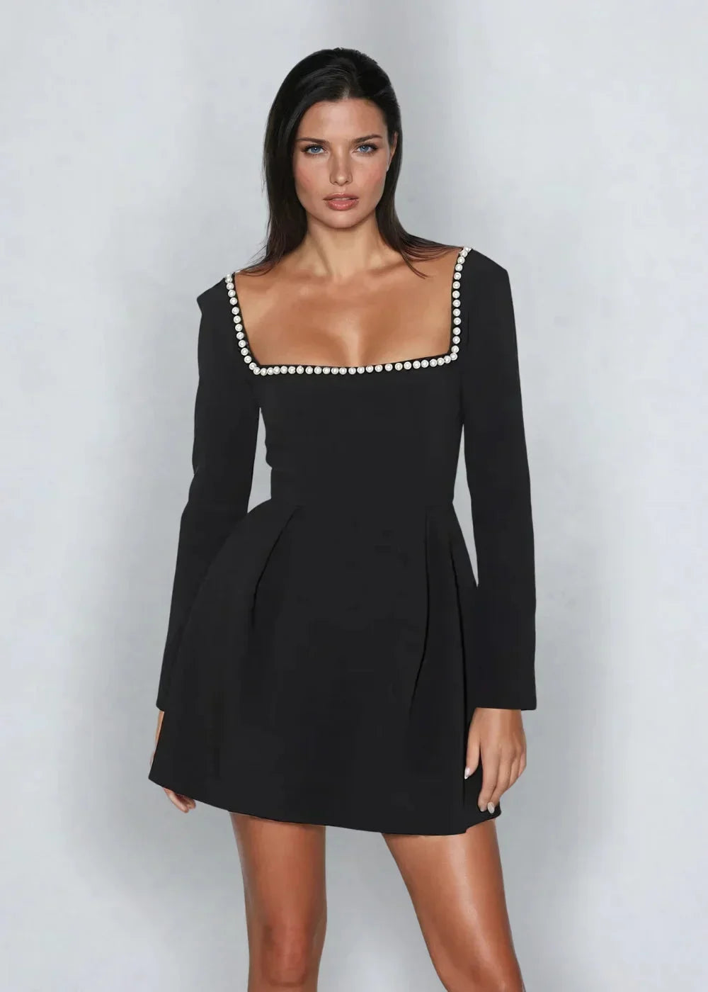 Robe courte col carré en tissu léger, décorée de perles, manches longues et jupe plissée élégante pour occasions spéciales.