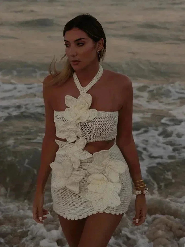 Robe courte blanche en crochet avec détails floraux découpés, idéale pour soirées estivales. Matière légère et aérée.