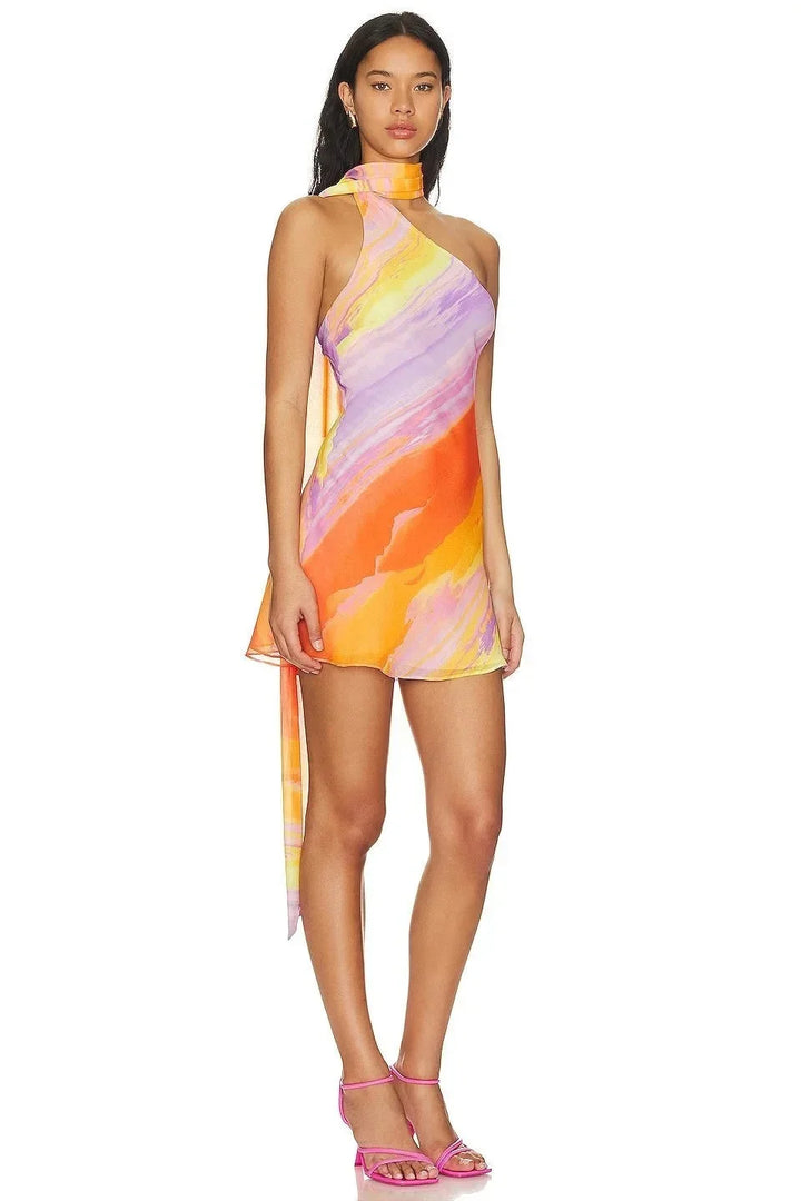 Robe courte dégradé aux couleurs du coucher de soleil, col licou, asymétrique, en tissu fluide parfait pour les soirées d'été.