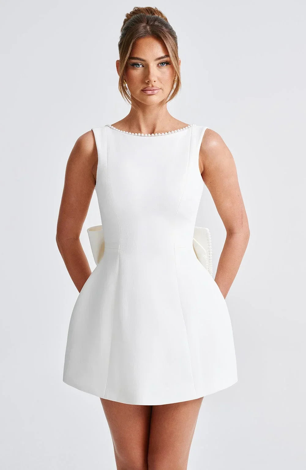 Robe courte dos nu ornée de perles et d'un gros nœud, en tissu léger, parfaite pour des soirées. Disponible en plusieurs…