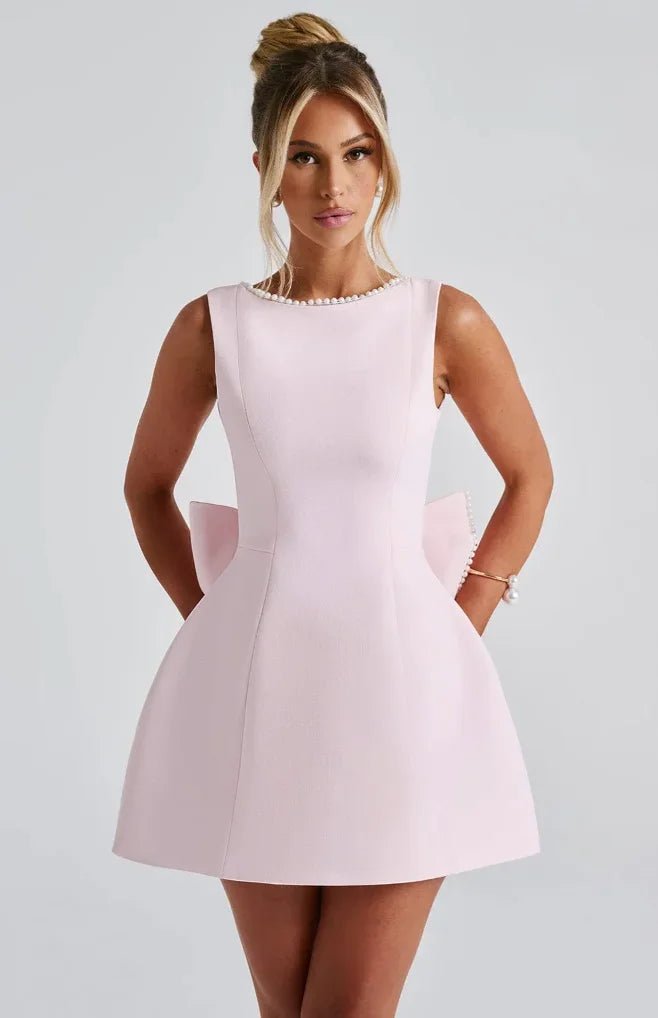 Robe courte dos nu en tissu léger, ornée de perles, avec un gros nœud. Idéale pour les soirées, disponible en plusieurs…