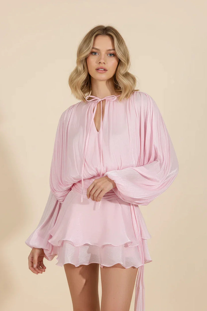 Robe mini femme en rose bébé, manches ballon, tissu fluide pour un style décontracté et confortable.