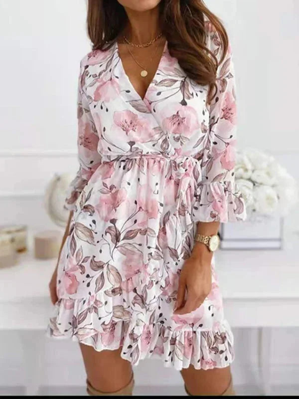 Robe courte fleurie avec col V, manches volantées et ceinture, en tissu léger et fluide, idéale pour l'été.