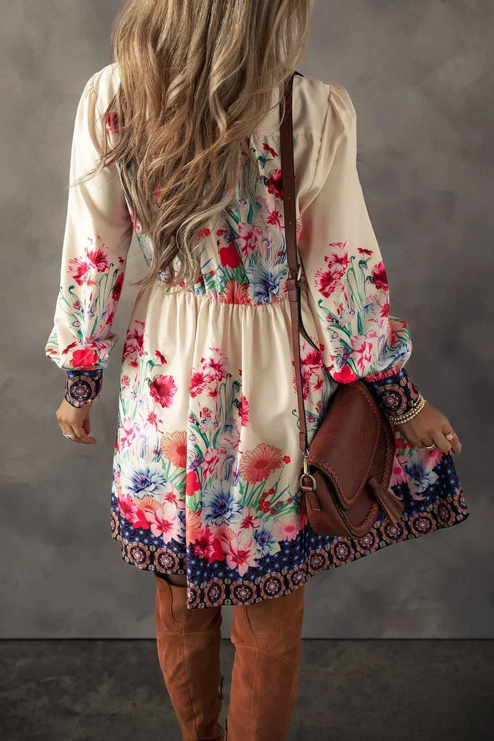 Robe courte fluide à imprimé floral multicolore, manches longues et tissu léger parfait pour les journées d'été.