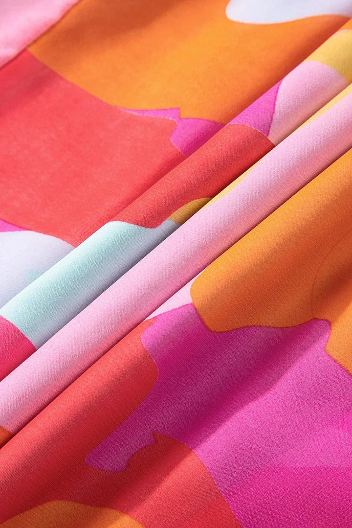 Robe courte décolletée en V, manches longues, tissu léger imprimé coloré, idéale pour une journée d'été à la plage.