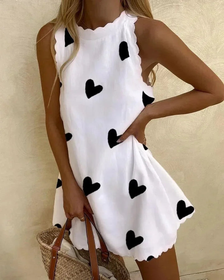 Robe courte sans manches, tissu léger, imprimé cœur et fleur, avec volants pour un style estival et décontracté.