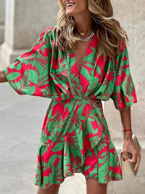 Robe courte rouge à motifs tropicaux, manches évasées, en tissu léger, parfaite pour les journées d'été à la plage.