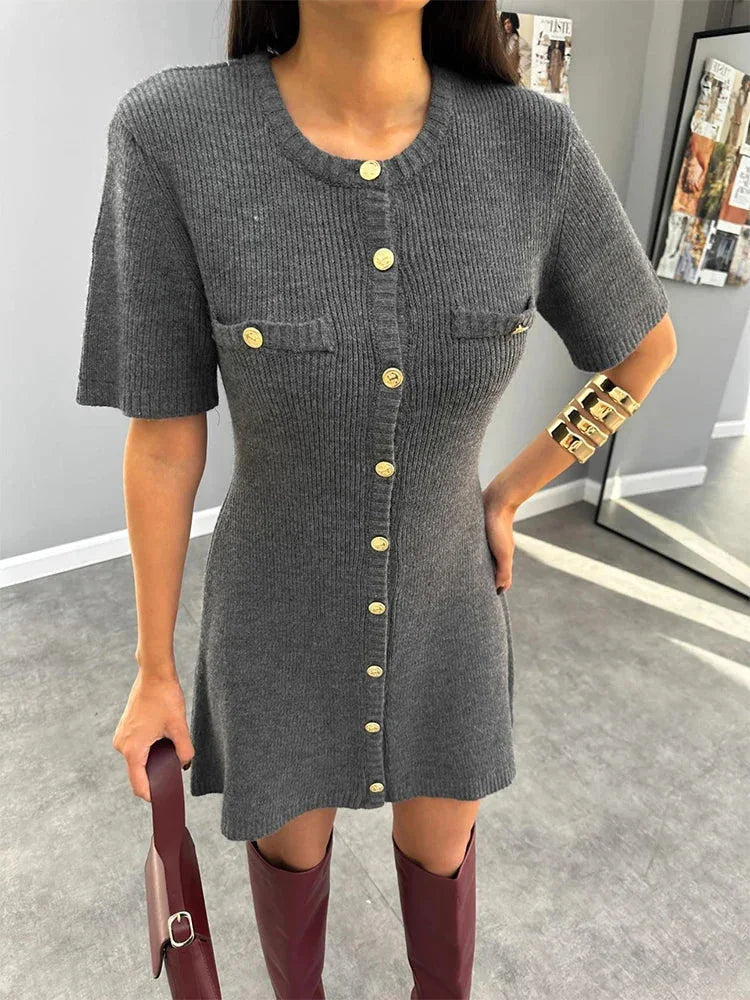 Robe mini en maille grise pour femme, dotée de boutons et de manches courtes, offrant un style décontracté et moderne.