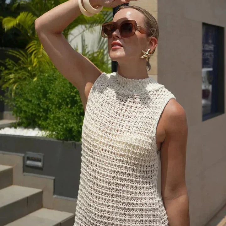 Robe courte ivoire en maille sans manches, ornée de franges, idéale pour un look décontracté à la plage cet été.
