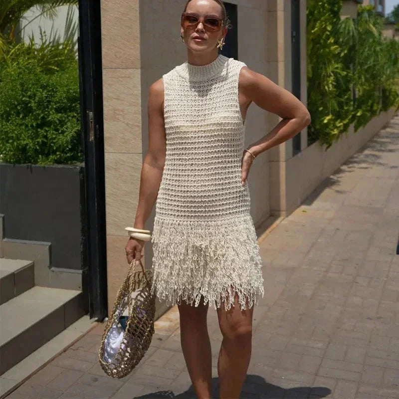 Robe courte en maille ivoire, sans manches, avec franges, idéale pour un look estival détendu à la plage.