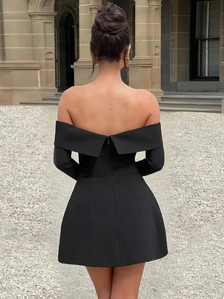 Robe courte élégante en tissu léger, manches longues, épaules dénudées, poches discrètes, idéale pour les soirées. Disponible…
