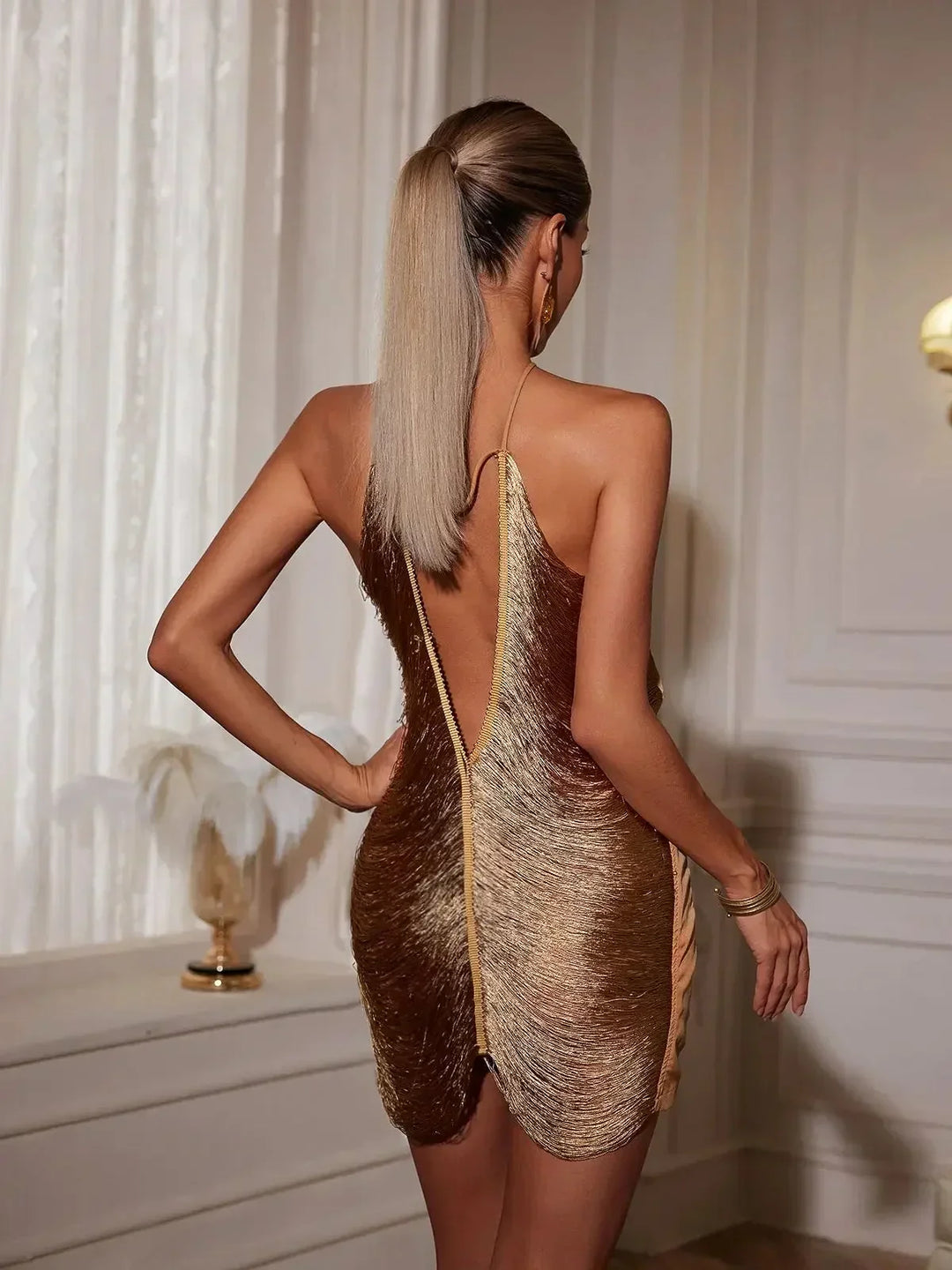 Robe courte en matériau métallique, design asymétrique avec fermeture éclair au dos, idéale pour les soirées en club.