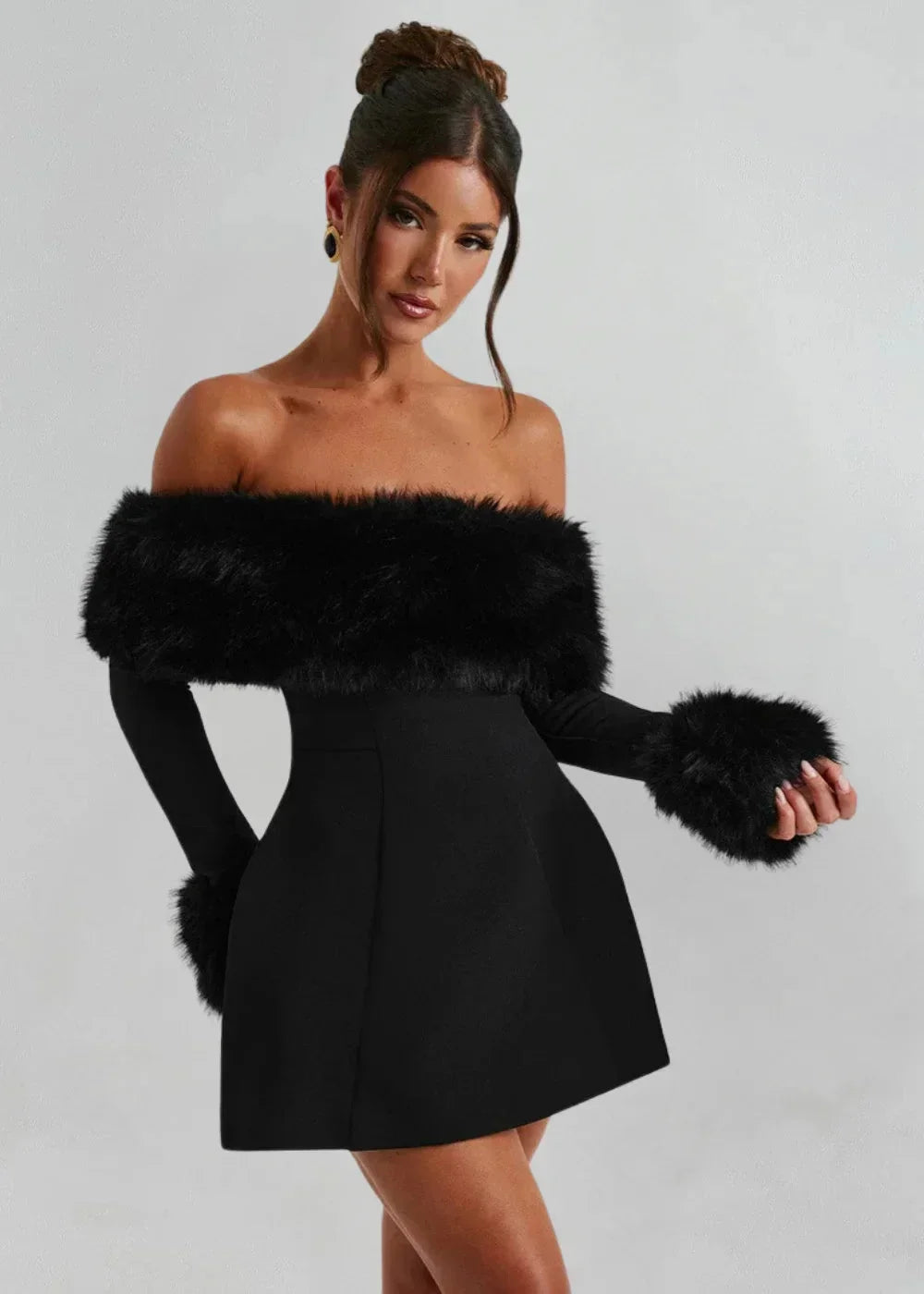 Robe courte noire à épaules dénudées, en tissu doux, avec accents en fourrure, idéale pour une soirée glamour.