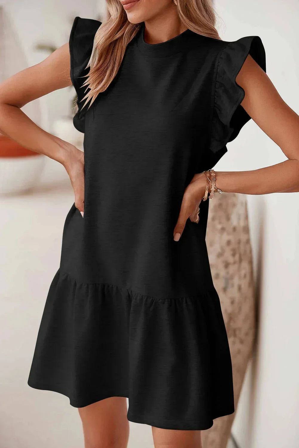 Robe courte noire à volants, manches courtes, en tissu léger, coupe trapèze, idéale pour les sorties soirée décontractées.