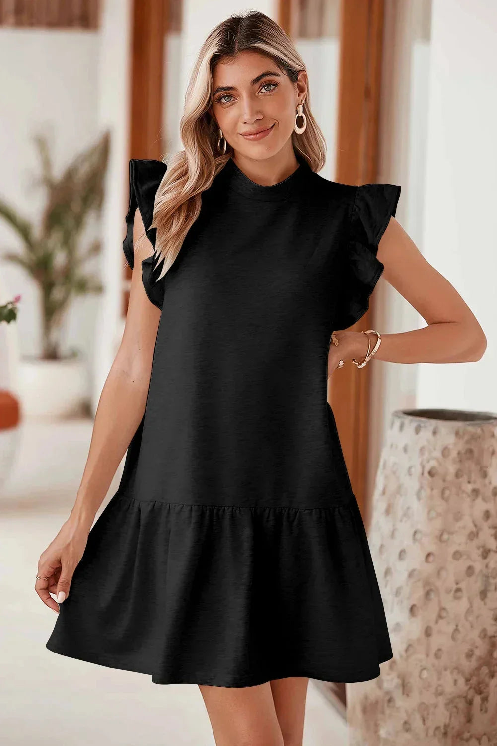 Robe courte noire à volants, manches courtes, coupe trapèze, en tissu léger, parfaite pour les sorties soirée.
