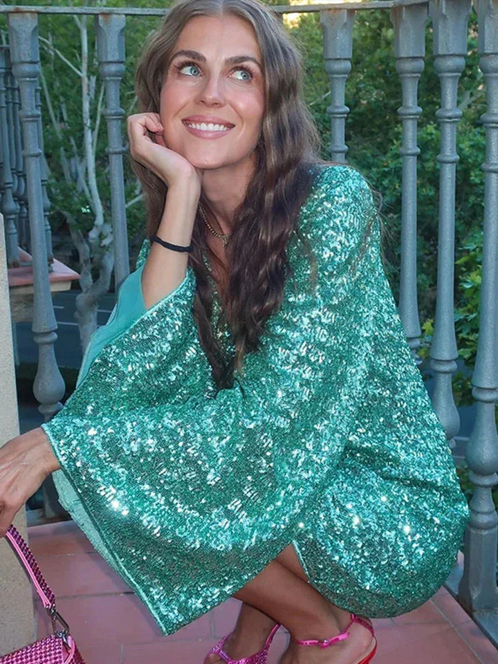 Robe courte en sequins avec col plongeant et manches évasées, idéale pour les soirées clubbing et les occasions festives.
