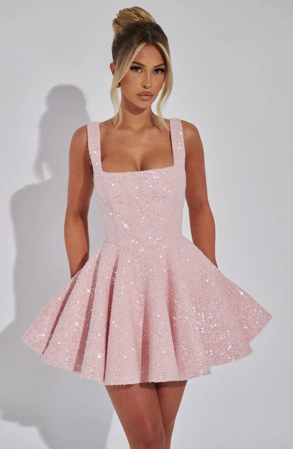 Robe courte pailletée fit and flare avec nœud, en tissu brillant, idéale pour des soirées clubbing modernes et élégantes.