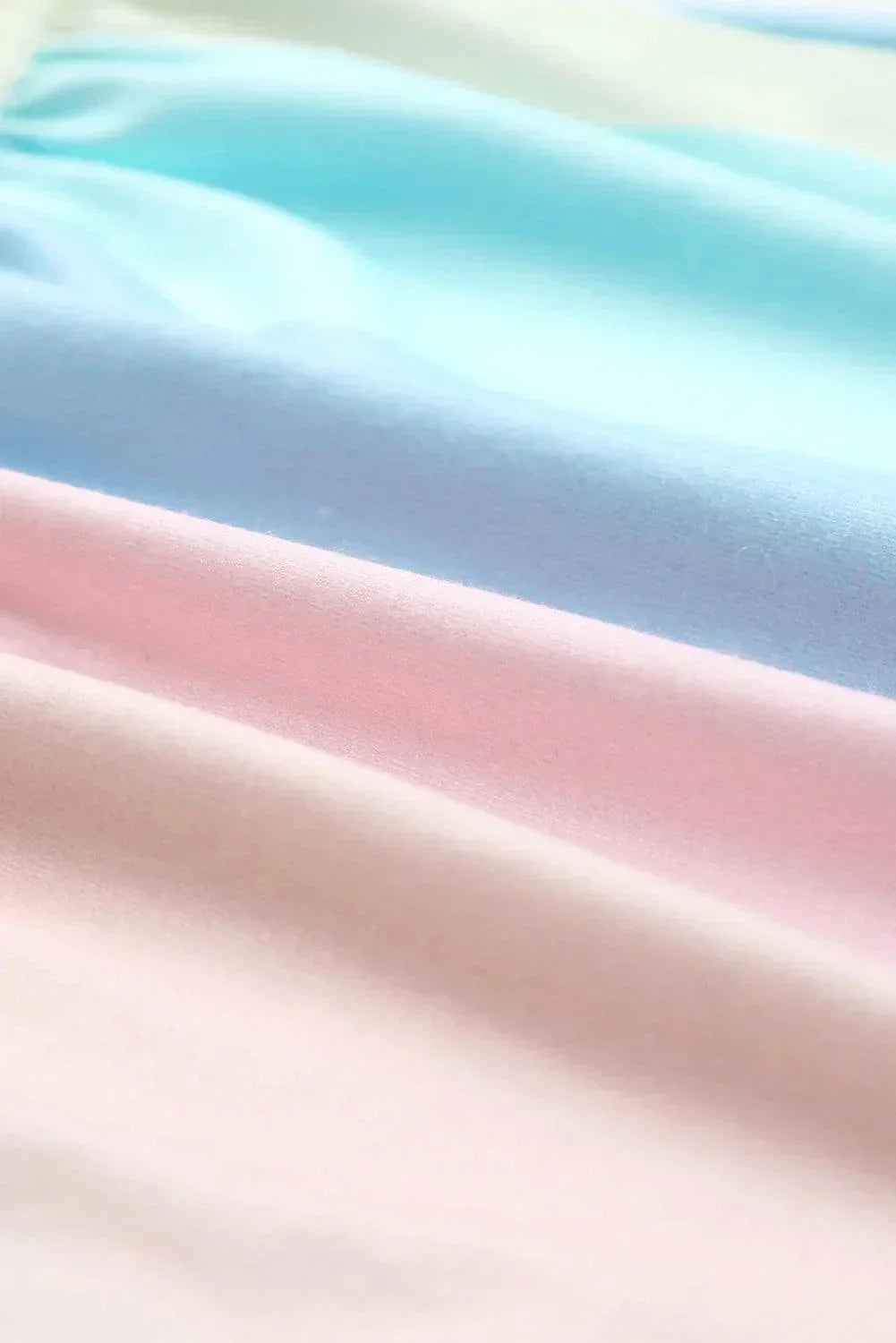 Robe courte pastel à volants, manches courtes, en tissu léger et fluide, parfaite pour des journées d'été à la plage.