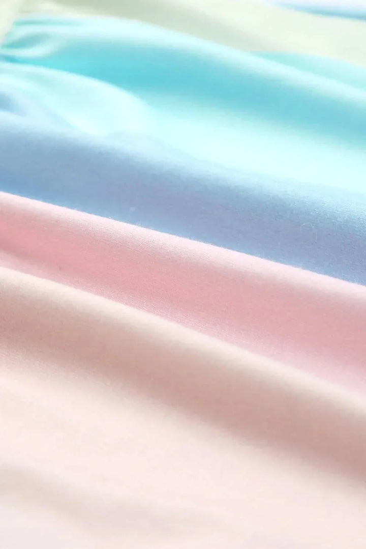 Robe courte pastel à volants, manches courtes, en tissu léger et fluide, parfaite pour des journées d'été à la plage.