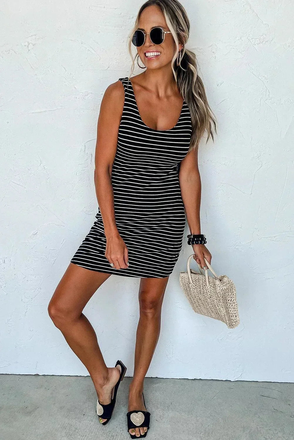 Robe courte rayée bleu marine et blanc, sans manches, en coton léger, parfaite pour des journées d'été à la plage.