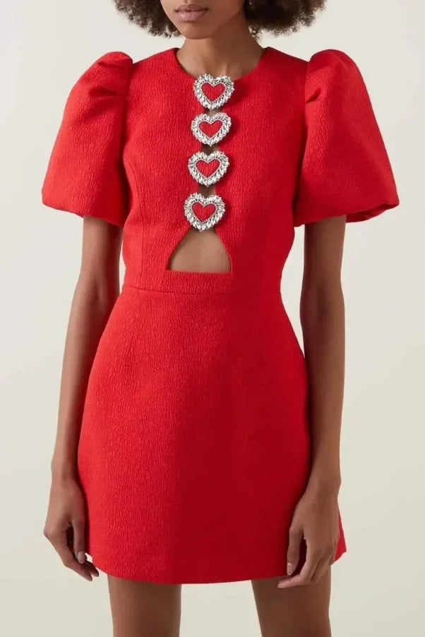 Robe courte rouge avec cœur en paillettes, manches bouffantes, en tissu léger idéal pour les soirées.
