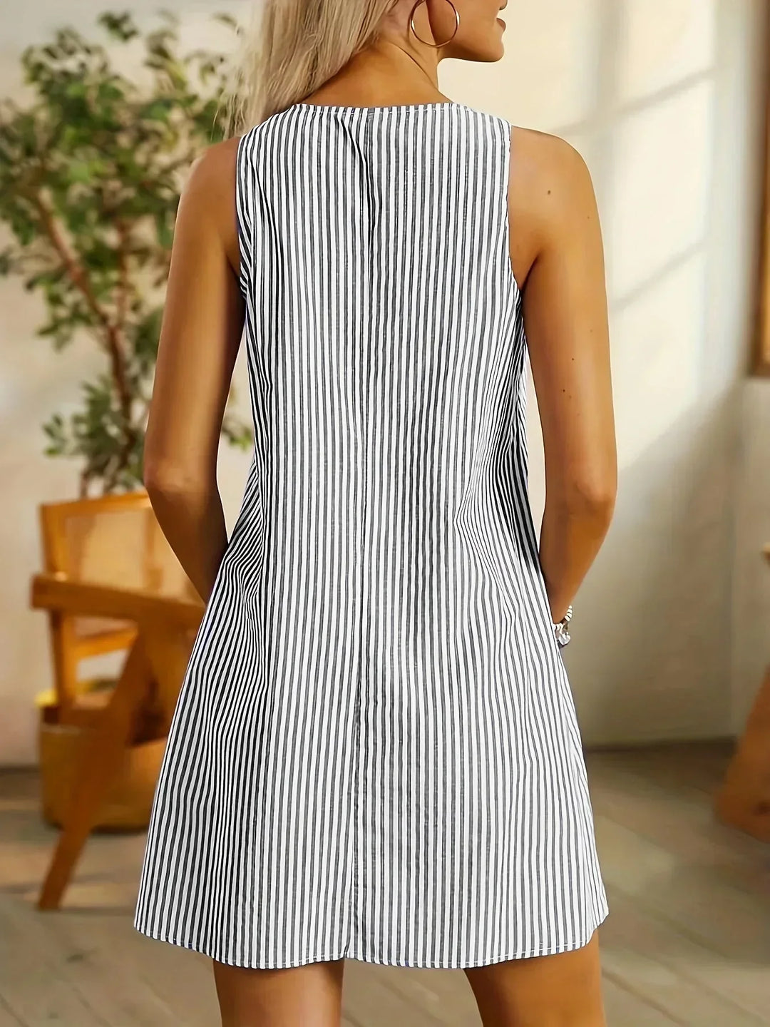 Robe courte sans manches, en coton léger, rayée avec boutons sur le devant et poches latérales, idéale pour l'été.