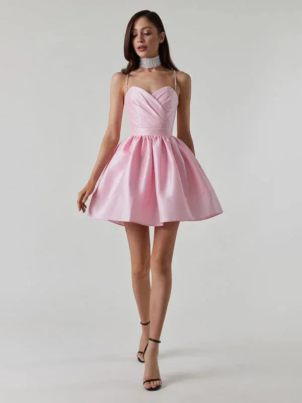 Robe courte satinée avec bretelles en strass, col en cœur et dos nu, disponible en plusieurs couleurs.