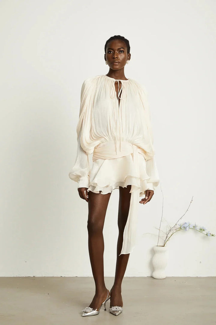 Robe fluide en satin avec manches longues et nœuds, parfaite pour les soirées, disponible en différentes couleurs.