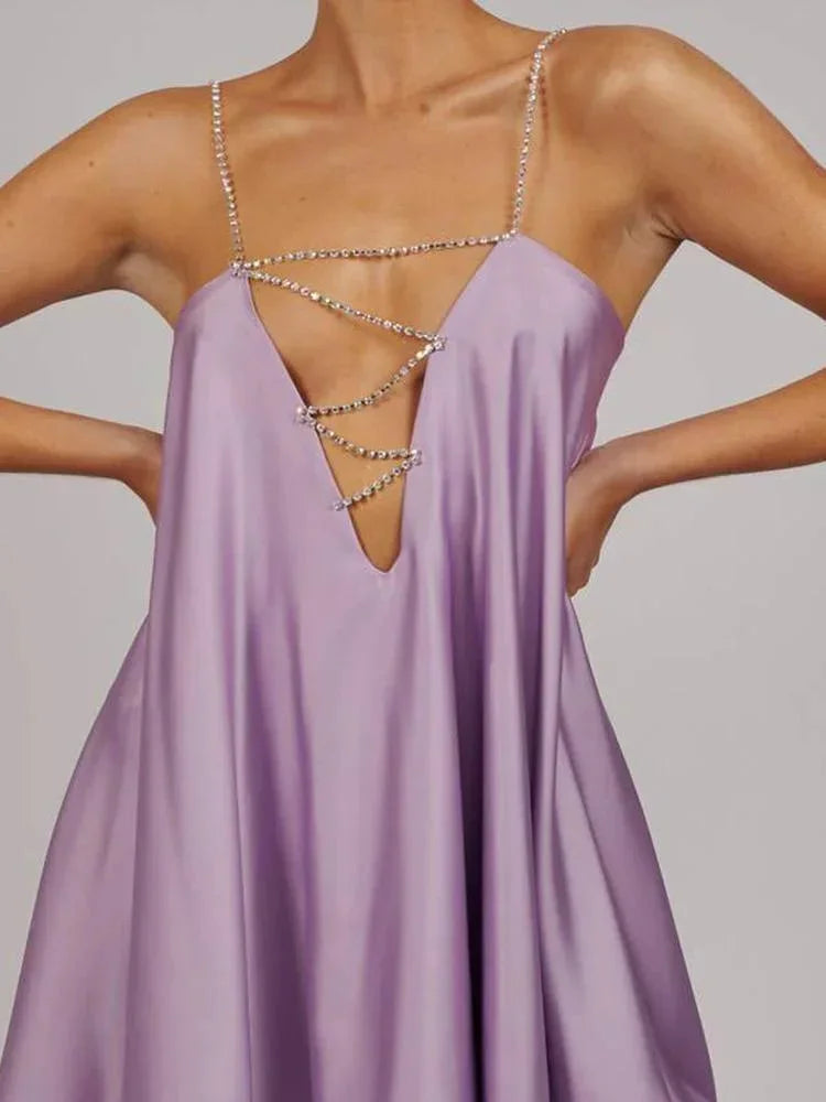 Robe courte fluide en satin avec chaînes décoratives, parfaite pour les soirées élégantes.