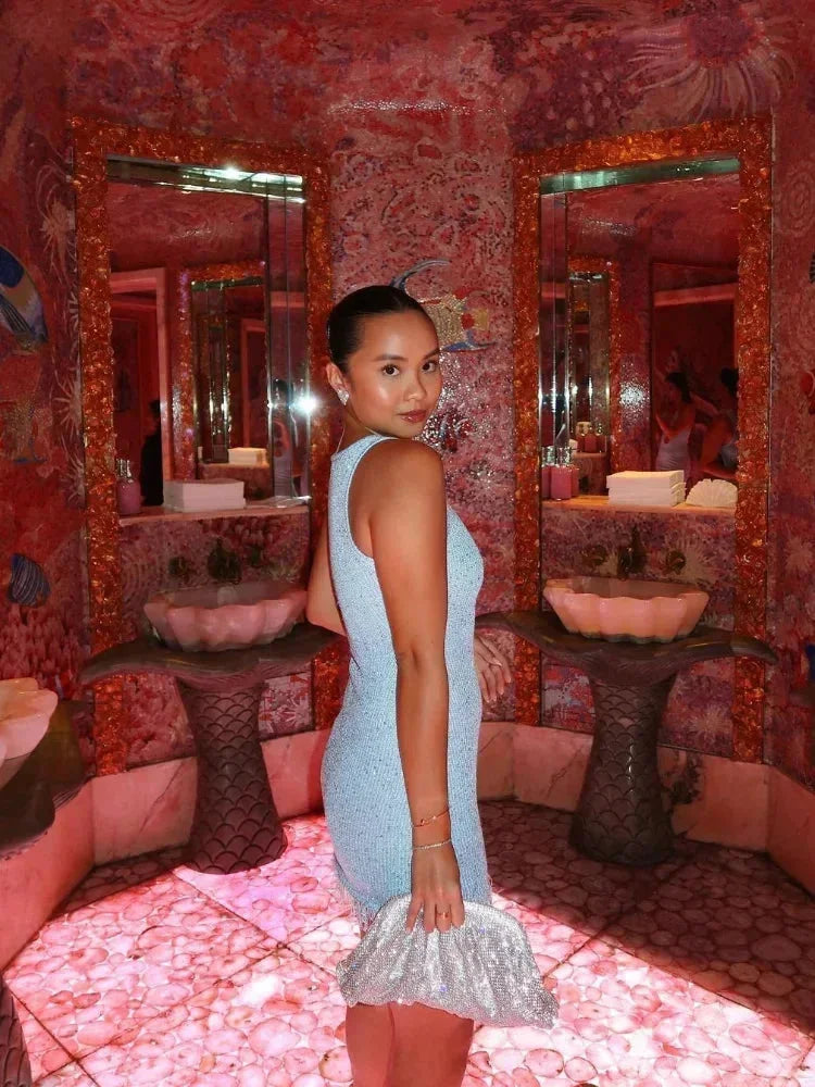 Robe courte sans manches en tissu brillant avec des franges, idéale pour les soirées clubbing et les danses.