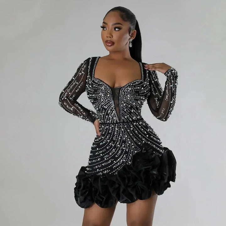 Robe courte noire à strass, manches longues, volants et décolleté plongeant, idéale pour les soirées élégantes.