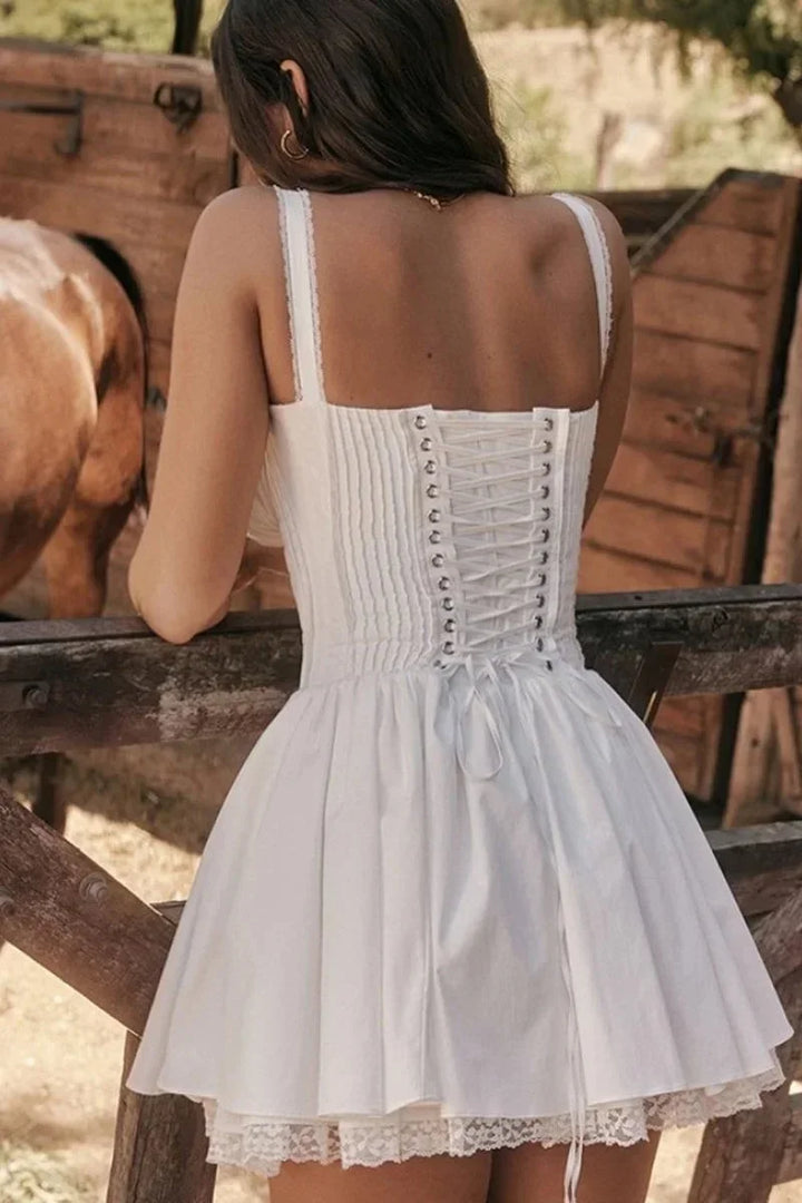 Robe courte évasée en tissu léger, avec décolleté froncé et bretelles multiples, disponible en plusieurs couleurs pour l'été.