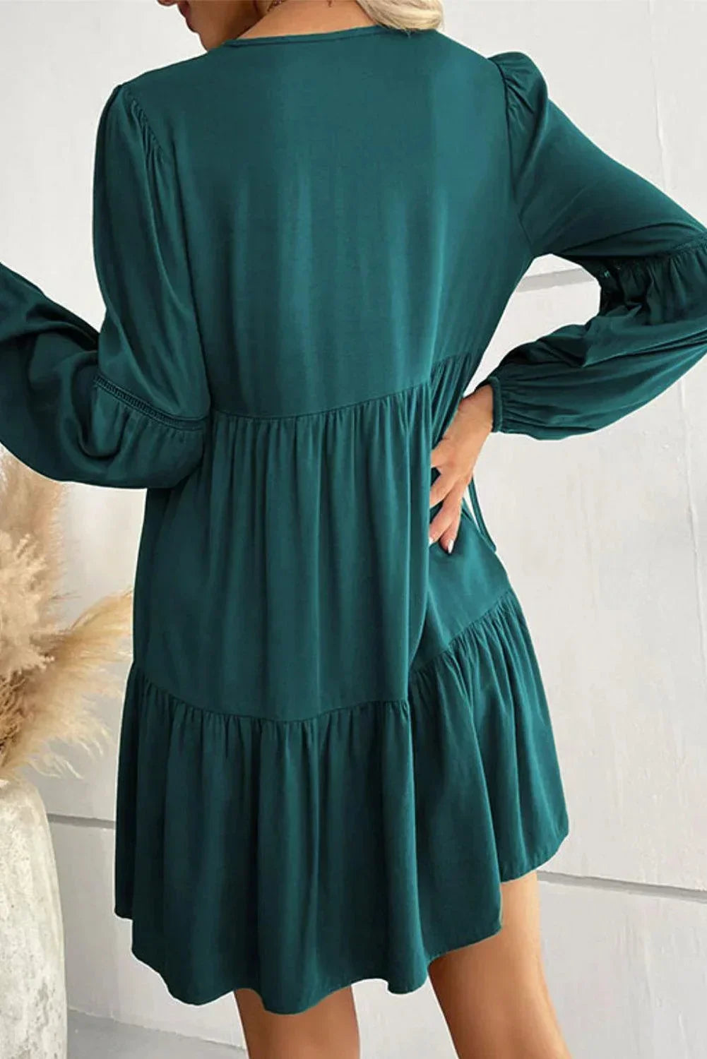 Robe courte volantée en tissu léger avec lacets et manches longues, parfaite pour les journées d'automne.