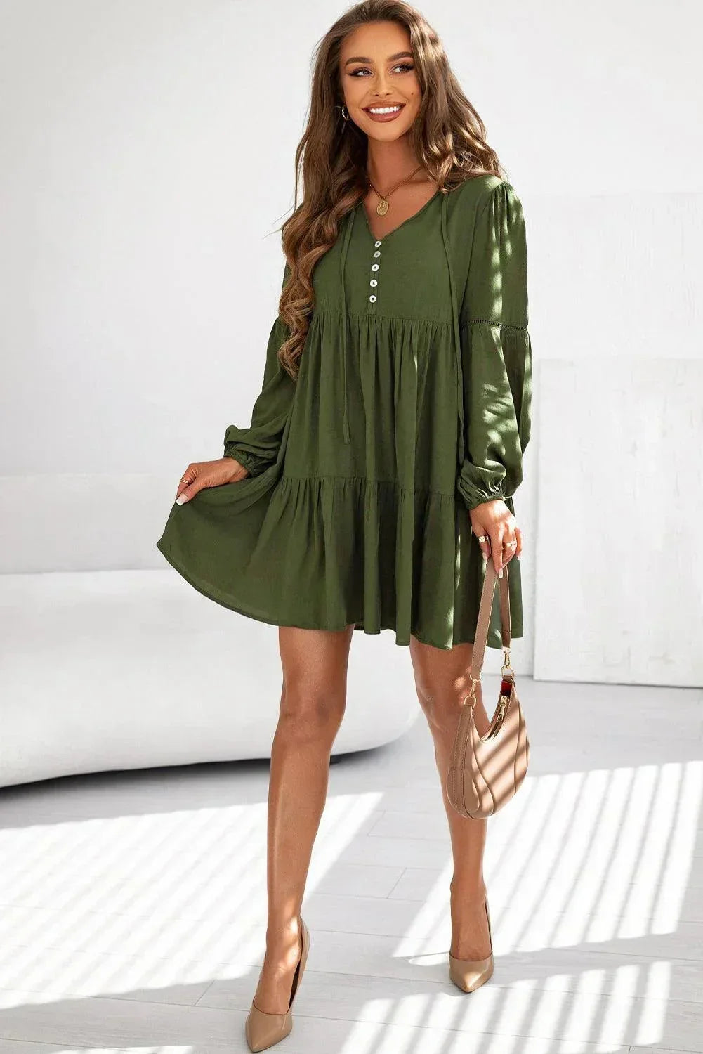 Robe courte volantée à lacets, manches longues en coton, avec un design automnal et une coupe fluide.