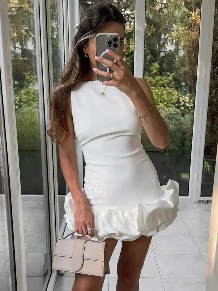 Robe courte volantée sans manches en coton léger, offrant une coupe fluide et disponible en plusieurs couleurs.