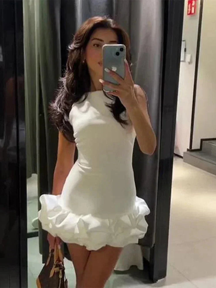 Robe courte volantée sans manches en coton léger, offrant une coupe fluide et disponible en plusieurs couleurs.