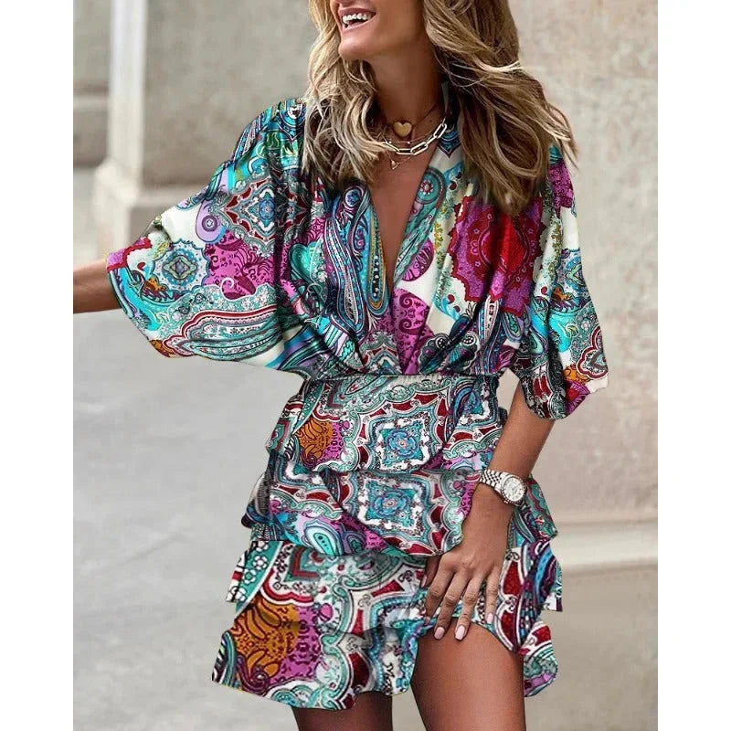Robe courte à volants, imprimée avec des motifs abstraits, décolleté plongeant et manches courtes, parfaite pour l'été.