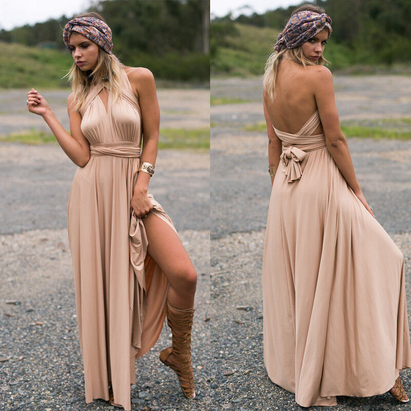 Donna con abito lungo beige senza spalline, sandali alti marroni e fascia colorata, in posa all'aperto. Moda estiva elegante e boho chic.