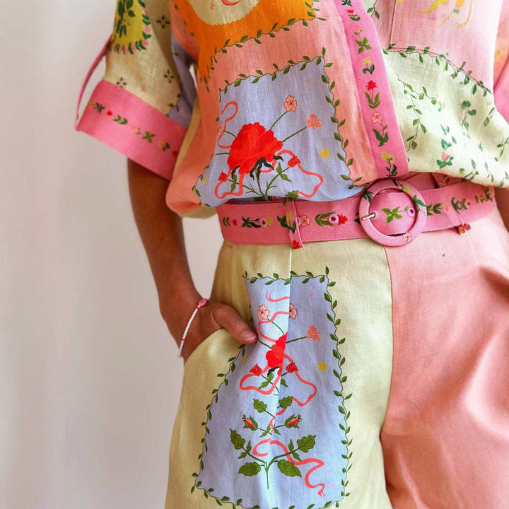 Completo estivo donna in lino colorato con motivi floreali, cintura coordinata e dettagli ricamati. Moda femminile, abbigliamento estivo elegante.