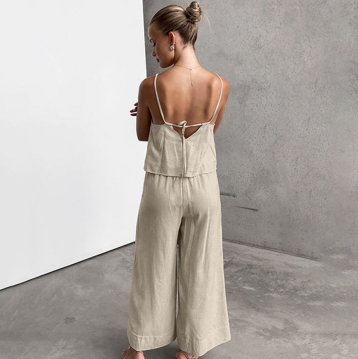 Donna in tuta beige senza maniche, vista posteriore, su sfondo grigio. Moda estiva, abbigliamento casual elegante, tessuto leggero.