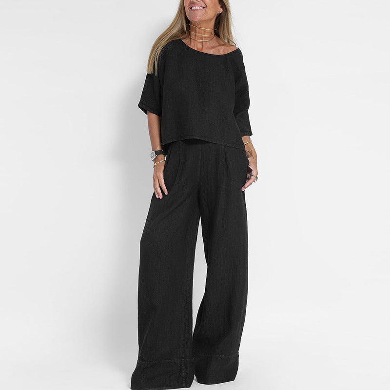 Donna con completo nero elegante, maglia a maniche corte e pantaloni larghi. Moda donna, abbigliamento casual chic, outfit estivo.