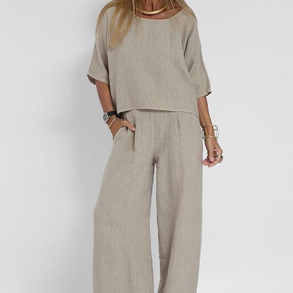 Donna con completo beige in lino, maniche corte, pantaloni larghi. Stile casual, moda estiva, abbigliamento donna elegante e confortevole.