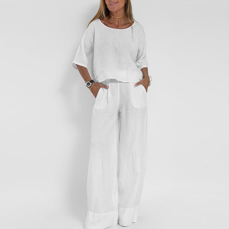 Donna in completo bianco estivo, maglia a maniche corte e pantaloni larghi. Moda casual elegante, abbigliamento leggero in lino.