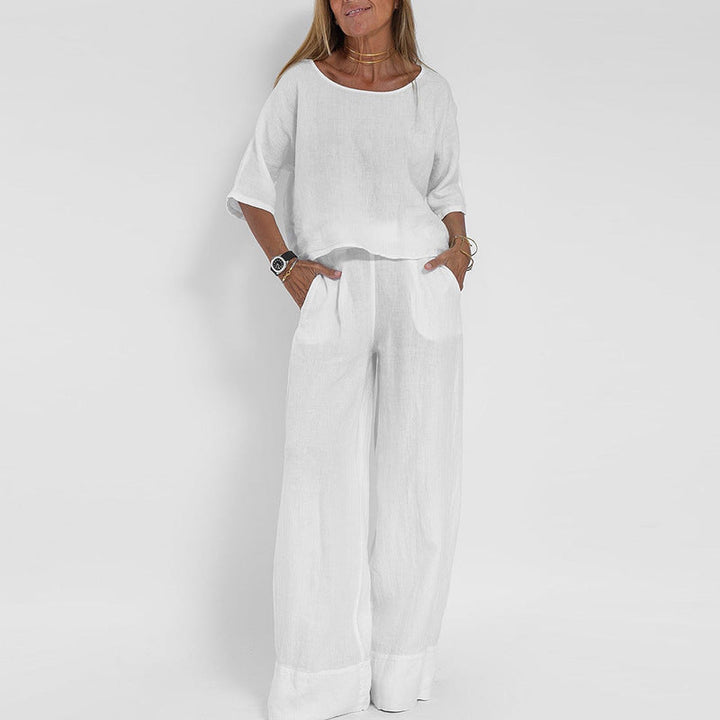 Donna in completo bianco estivo, maglia a maniche corte e pantaloni larghi. Moda casual elegante, abbigliamento leggero in lino.