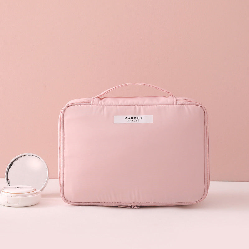 Borsa trucco rosa con manico, design elegante, ideale per organizzare cosmetici. Include specchietto compatto. Accessorio da viaggio essenziale.