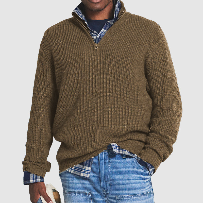 Maglione uomo marrone a collo alto con zip, indossato sopra camicia a quadri blu e jeans. Moda casual autunno inverno, abbigliamento maschile elegante.