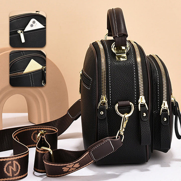 Borsa a tracolla in pelle nera con doppia cerniera, tasche multiple e dettagli in metallo dorato. Design elegante e funzionale per uomo e donna.