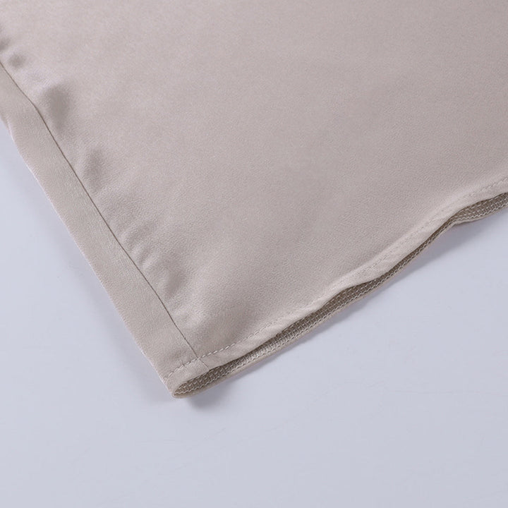Cuscino in seta beige su sfondo bianco, tessuto liscio e lucido, ideale per arredamento elegante e comfort. Accessorio casa di lusso.